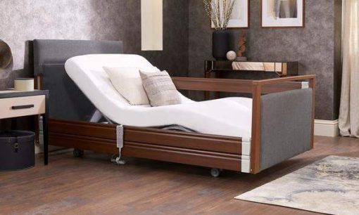 Upholstered profiling care bed in Walnut in bedroom